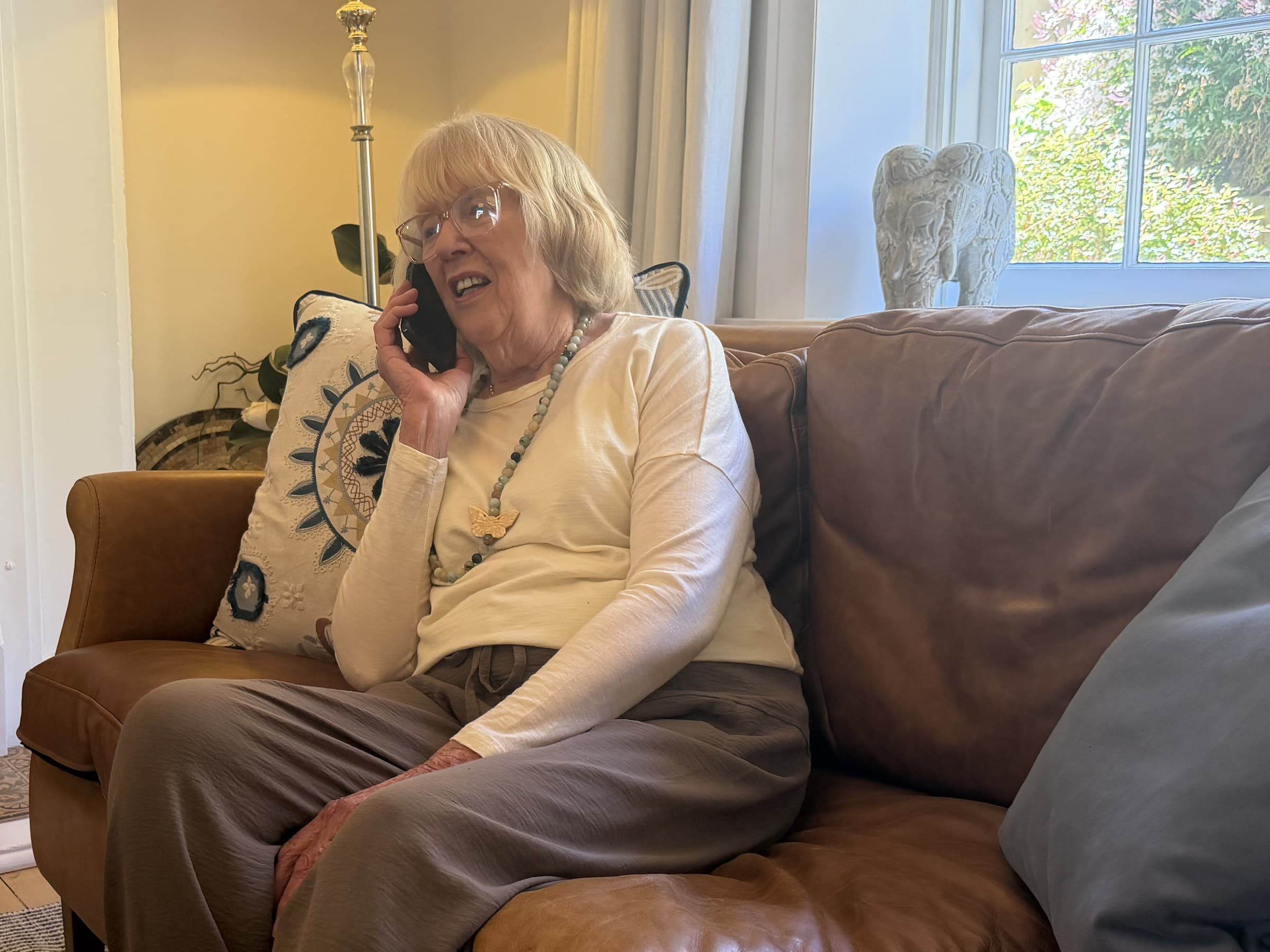 A woman chatting on the phone on her sofa at home